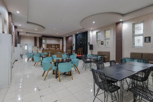 a dining room with tables and chairs in a restaurant at RedDoorz Syariah @ Klojen Malang in Malang