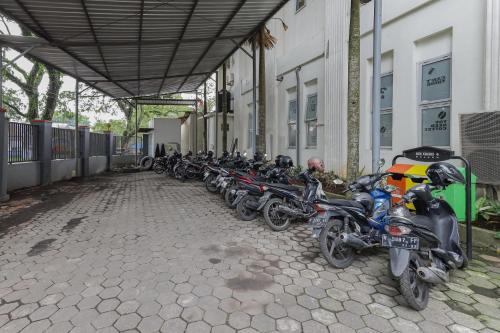 a row of motorcycles parked next to a building at RedDoorz Syariah @ Klojen Malang in Malang