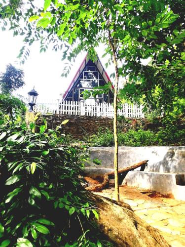 a house with a white fence and a tree at Riverston Nature Villa in Rattota