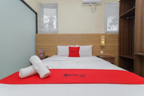 a bedroom with a bed with two towels on it at RedDoorz Syariah @ Klojen Malang in Malang