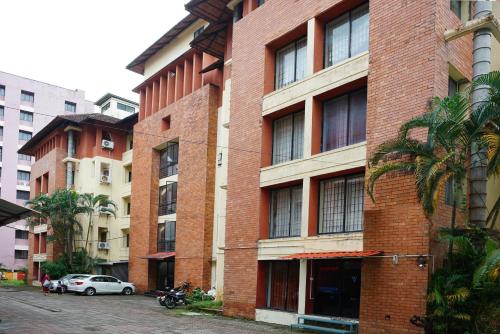 a brick building with a car parked in front of it at Vrindavan Suites Guruvayur in Guruvāyūr