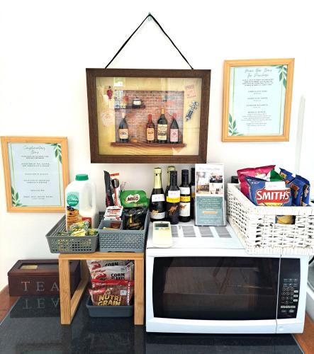 a microwave on a counter with food and drinks at Don Valley Lodge in Launching Place