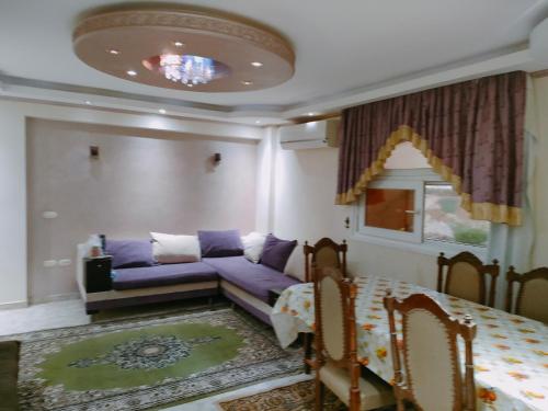 Super Deluxe apartment with 3 Bed rooms في شرم الشيخ: غرفة معيشة مع أريكة أرجوانية وطاولة