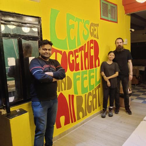 a group of people standing in front of a yellow wall at Friends Guest House & Hostel- near TAJ MAHAL in Agra