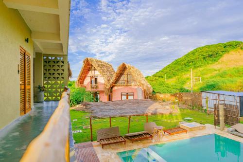 a house with a thatched roof and a swimming pool at Casa Mambo Salinas in Santa Veronica