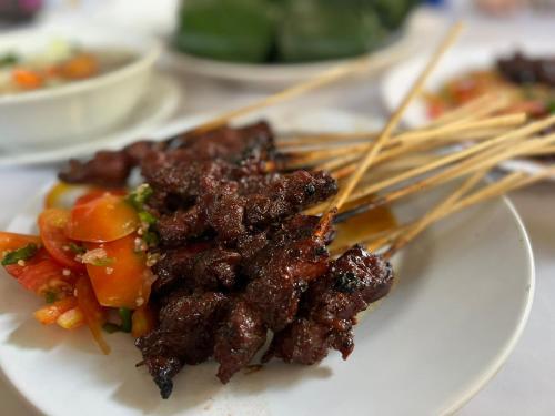 a plate of food on a table with chop sticks at Grand Ciwareng Inn Hotel and Resort in Pasarsenen