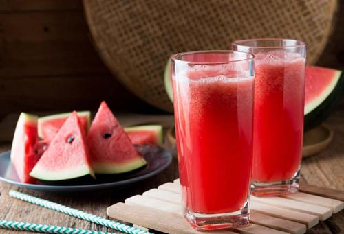 two glasses of watermelon juice and a plate of watermelon slices at Grand Ciwareng Inn Hotel and Resort in Pasarsenen