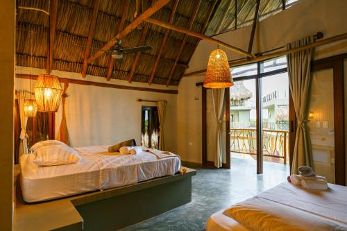 a bedroom with two beds and a balcony at Casa Mambo Salinas in Santa Veronica