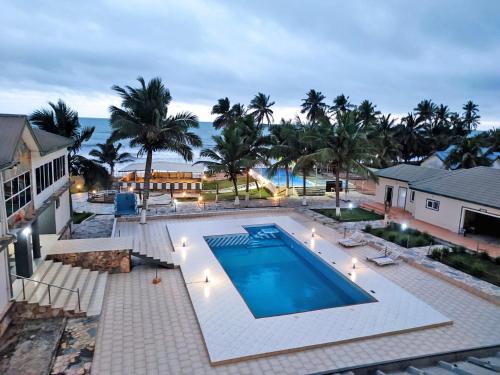 een uitzicht over een zwembad met palmbomen bij ELLISA HOSPITALITY and SPA in Accra