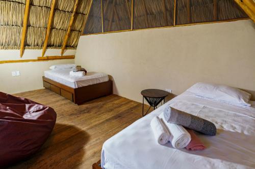 a bedroom with two beds and a table and a tableasteryasteryasteryasteryastery at Casa Mambo Salinas in Santa Veronica