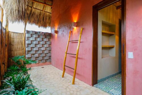 a room with a pink wall with a ladder next to a door at Casa Mambo Salinas in Santa Veronica