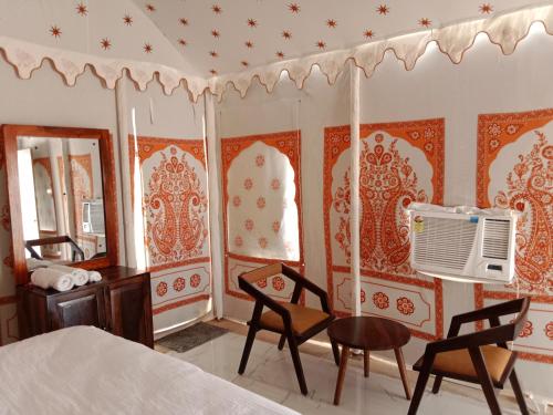 a bedroom with a bed and a table and chairs at Sunny Desert Camp in Kūri