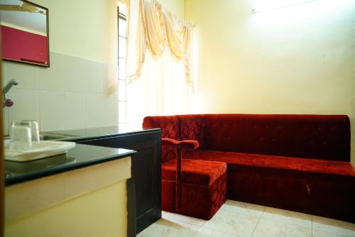 a bathroom with a red couch and a sink at Vrindavan Suites Guruvayur in Guruvāyūr
