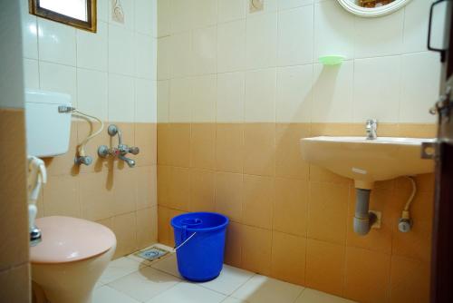 a bathroom with a sink and a toilet at Vrindavan Suites Guruvayur in Guruvāyūr
