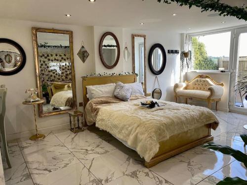 1 dormitorio con 1 cama grande y espejos en la pared en Beautiful Boutique With own Hot Tub & Pet Friendly, en Stokeinteignhead