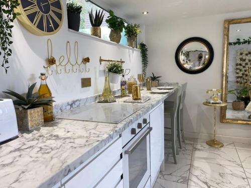 a kitchen with a marble counter top and a clock on the wall at Beautiful Boutique With own Hot Tub & Pet Friendly in Stokeinteignhead