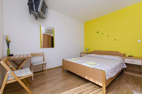 a bedroom with a bed and a table and a desk at Apartments and rooms Mini - parking in Bol