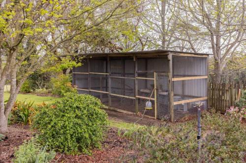 a small shed in a garden with a fence at Graelynn Farm in Mangrove Mountain