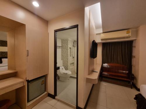 a small bathroom with a toilet and a mirror at Cozi Inn Hotel, Bangkok in Bangkok