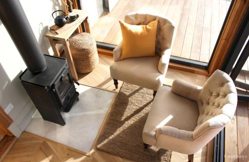 sala de estar con 2 sillas y fogones en Compass Hut, en Melrose