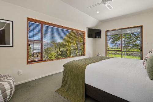 1 dormitorio con 1 cama grande y 2 ventanas en Welcome Home - Hanmer Springs Holiday Home, en Hanmer Springs