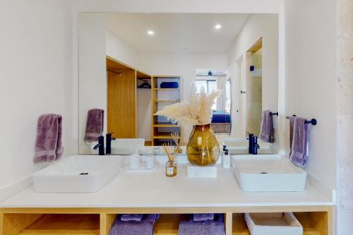 a bathroom with two sinks and a vase with flowers at Montemar D 502 in Cabo San Lucas