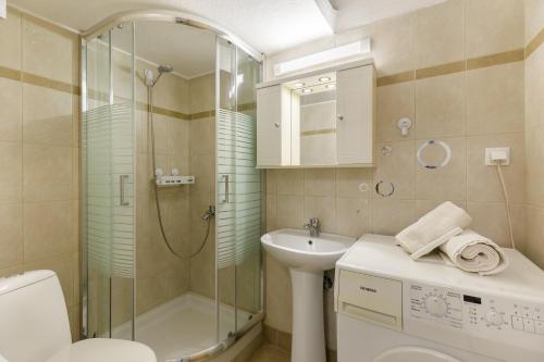 ein Bad mit einer Dusche, einem WC und einem Waschbecken in der Unterkunft PEARL STUDIO free private parking in Thessaloniki