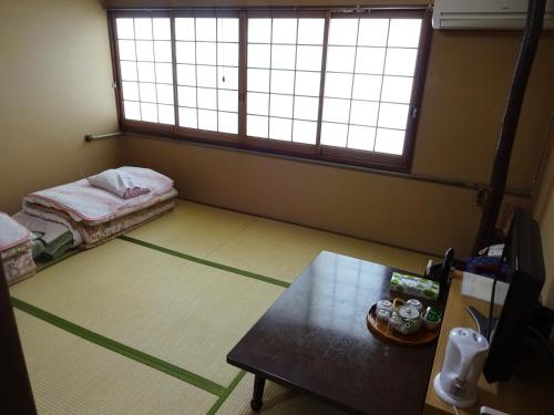 ein leeres Zimmer mit einem Bett und einem Tisch darin in der Unterkunft Imazato Ryokan - Vacation STAY 02545v in Osaka