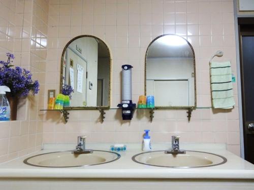 ein Badezimmer mit zwei Waschbecken und zwei Spiegeln in der Unterkunft Imazato Ryokan - Vacation STAY 02547v in Osaka