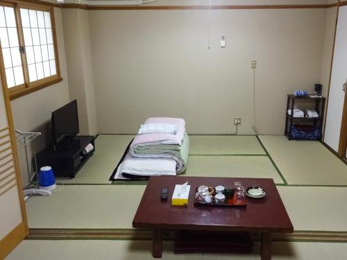 ein Zimmer mit einem Bett und einem Tisch darin in der Unterkunft Imazato Ryokan - Vacation STAY 02547v in Osaka