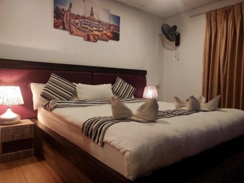 The Glasshouse Hotel في Kawasoti: غرفة نوم بسرير كبير مع وسادتين