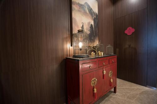 a red dresser with a bird cage on top of it at Ashley Tang Menteng Jakarta in Jakarta