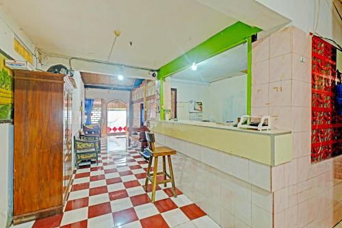 a kitchen with a counter and a checkerboard floor at SPOT ON 91915 Homestay Superman in Yogyakarta