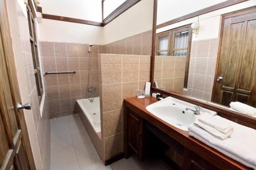 bagno con lavandino e specchio di Ndalem Maharani Guest House a Yogyakarta