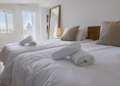 2 witte bedden met handdoeken in een slaapkamer bij Ático nuevo en lujosa urbanización junto a restaurantes y cafeterías in Marbella