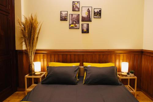 um quarto com uma cama com 2 candeeiros e fotografias na parede em TAP Homestay Ngọc Hà Ba Đình Hà Nội em Hanói