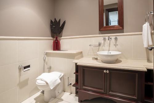 bagno con lavandino, servizi igienici e specchio di Zaafaran Tower 2 - 2BR Apartment - Allsopp&Allsopp a Dubai