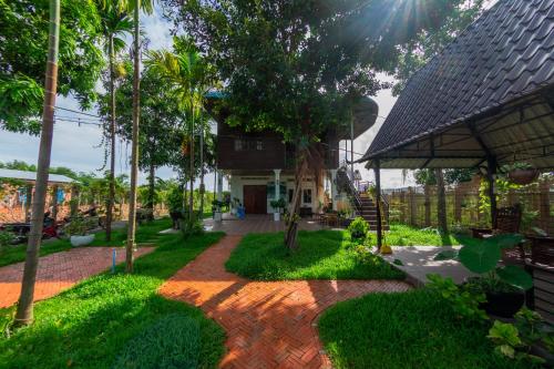 um jardim com um passadiço de tijolos em frente a uma casa em The Green Home em Siem Reap