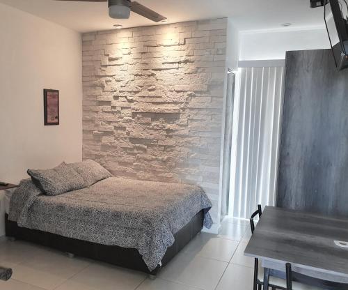 a bedroom with a bed and a brick wall at Habitaciones amuebladas Veracruz Logos in Veracruz