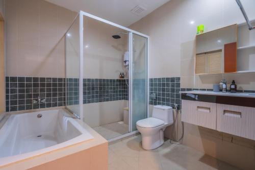 a bathroom with a tub and a toilet and a shower at Cozy 2 bedroom w pool for 6 - Seri Kembangan in Seri Kembangan