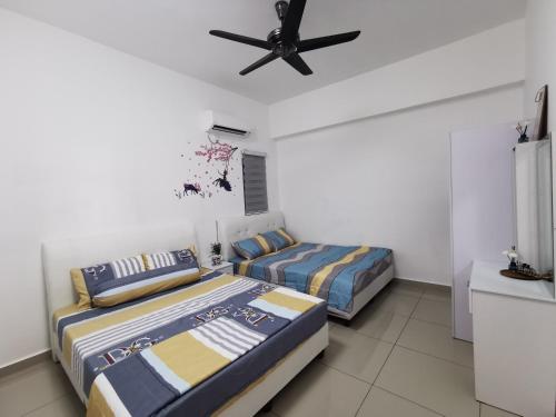 sypialnia z 2 łóżkami i wentylatorem sufitowym w obiekcie Coco HomeStay 旅人の家@The Venus Sitiawan Perak w mieście Sitiawan