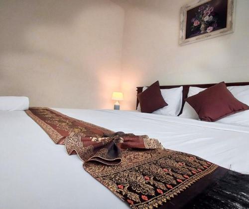 a bed with a patterned blanket on top of it at Baanloksouylokchay in Hua Hin