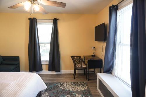 um quarto com uma cama, uma cadeira e uma secretária em Lincoln Manor - Newly Renovated, 1mile from PHL Airport and Sports Stadiums em Prospect Park