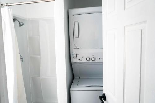 a white washer and dryer in a bathroom at Lincoln Manor - Newly Renovated, 1mile from PHL Airport and Sports Stadiums in Prospect Park