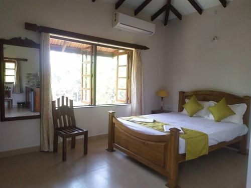 1 dormitorio con 1 cama, 1 silla y 1 ventana en Palmeiral BeachVilla en Calangute