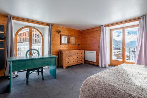 Schlafzimmer mit einem Schreibtisch, einem Bett und einem Fenster in der Unterkunft La Chapelle Aux Pieds Des Pistes in Chamonix-Mont-Blanc