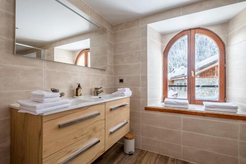 La salle de bains est pourvue d'un lavabo et d'un miroir. dans l'établissement La Chapelle Aux Pieds Des Pistes, à Chamonix-Mont-Blanc