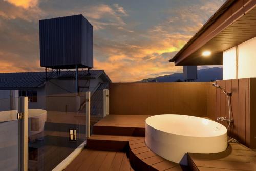 uma casa de banho com banheira numa varanda em Be Phrasingh Hotel Chiang Mai em Chiang Mai