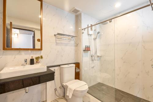 a bathroom with a toilet and a sink and a shower at Be Phrasingh Hotel Chiang Mai in Chiang Mai