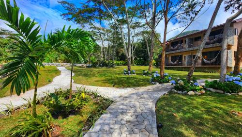 a walkway leading to a house with palm trees at Rio Verde by Villa Alejandro in Boquete